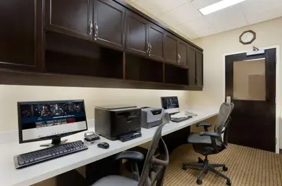 an office with a desk with a computer and chairs at Hilton Garden Inn Edmonton International Airport in Leduc