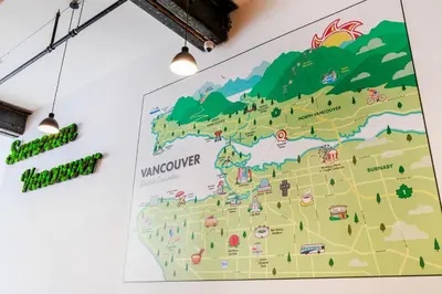 a map hanging on a wall with lights at Samesun Vancouver in Vancouver
