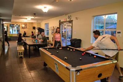 a group of people playing pool in a room at HI Kelowna Hostel in Kelowna