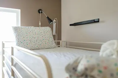 a bedroom with a bed with a pillow and a lamp at HI Kelowna Hostel in Kelowna