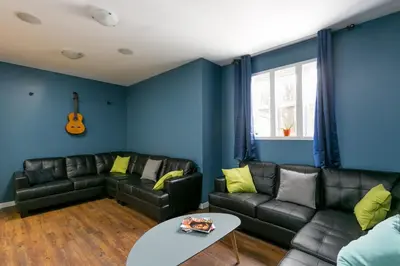 a living room with a couch and a table at HI Kelowna Hostel in Kelowna