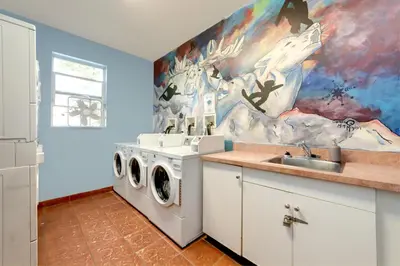 a kitchen with a washing machine and a sink at HI Kelowna Hostel in Kelowna