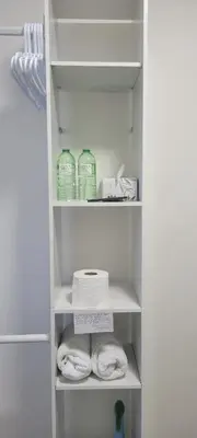 a white closet with towels and detergents at Farhad's B&B in Abbotsford
