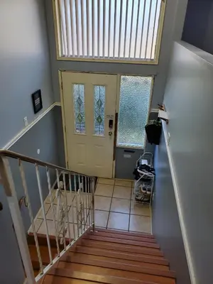 a staircase with a yellow door in a house at Farhad's B&B in Abbotsford