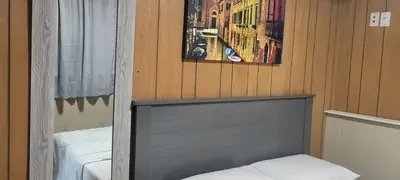 a bedroom with a bed and a picture on the wall at Farhad's B&B in Abbotsford