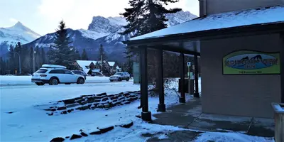 a snow covered street with cars parked next to a building at Mountain View Inn in Canmore
