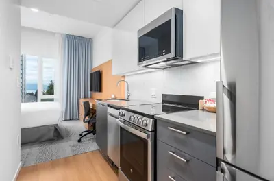 a kitchen with a sink and a stove top oven at West Coast Suites at UBC in Vancouver