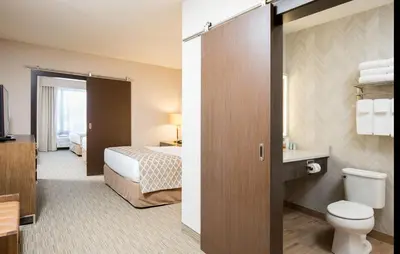 a hotel room with a bed and a toilet at Pomeroy Inn & Suites Prince George in Prince George