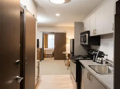 a kitchen with a sink and a microwave at Pomeroy Inn & Suites Prince George in Prince George