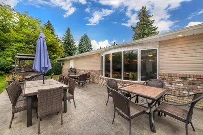 a patio with tables and chairs and an umbrella at Best Western Sicamous Inn in Sicamous