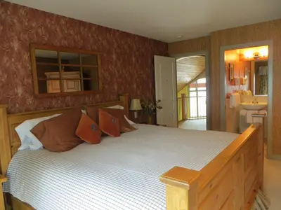 a bedroom with a large wooden bed with orange pillows at Buffaloberry Bed & Breakfast in Banff