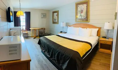 a hotel room with a large bed and a desk at Armstrong Inn in Armstrong