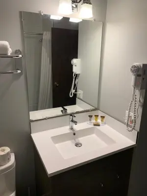 a bathroom with a sink with a mirror and a phone at Armstrong Inn in Armstrong