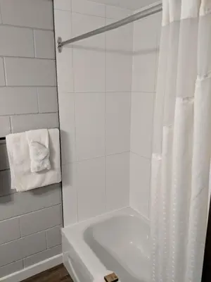 a white bathroom with a tub and a shower at Armstrong Inn in Armstrong