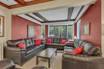 a living room with leather furniture and red walls at HI Penticton - Hostel in Penticton