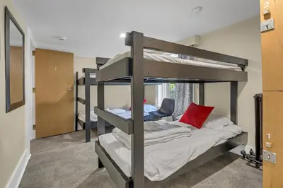 a room with two bunk beds with a chair at HI Penticton - Hostel in Penticton