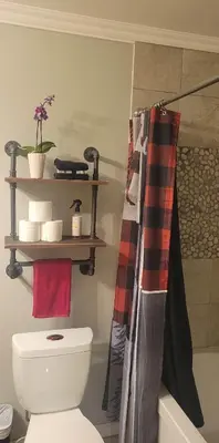 a bathroom with a toilet and a shelf on the wall at Riverbend Guest House in Chilliwack