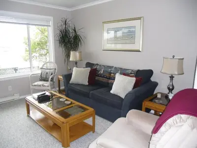 a living room with a blue couch and a coffee table at Hammond Bay Oceanside Guesthouse in Nanaimo