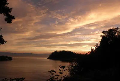 a sunset over a body of water at Hammond Bay Oceanside Guesthouse in Nanaimo