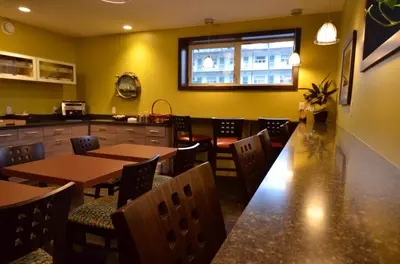 a restaurant with tables and chairs and a window at The Pacific Inn in Prince Rupert