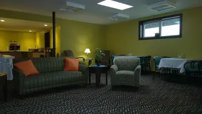 a waiting room with a couch and chairs and tables at The Pacific Inn in Prince Rupert