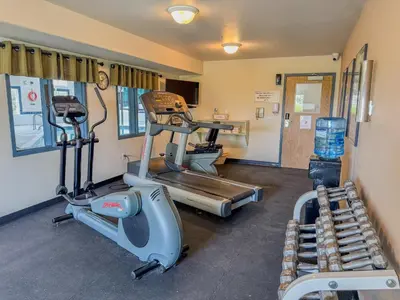 a gym with two exercise bikes and a treadmill at Super 8 by Wyndham High River AB in High River