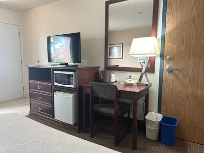 a hotel room with a desk with a television and a lamp at Super 8 by Wyndham High River AB in High River