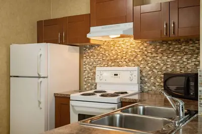 a kitchen with a white refrigerator and a sink at Days Inn by Wyndham Cranbrook Conference Centre in Cranbrook