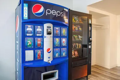 a pepsi soda machine is next to a refrigerator at Days Inn by Wyndham Cranbrook Conference Centre in Cranbrook