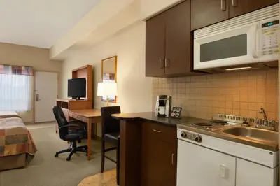 a kitchen with a sink and a desk in a room at Ramada by Wyndham Drayton Valley in Drayton Valley