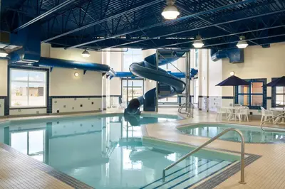 a swimming pool with a slide in a building at Ramada by Wyndham Drayton Valley in Drayton Valley