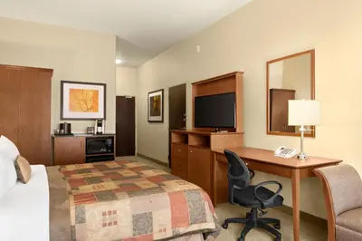 a hotel room with a bed and a desk with a computer at Ramada by Wyndham Drayton Valley in Drayton Valley