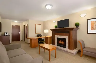 a living room with a fireplace and a tv at Ramada by Wyndham Drayton Valley in Drayton Valley