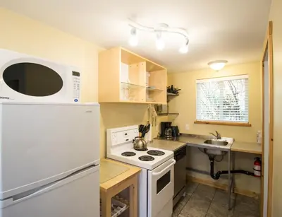 a kitchen with a white refrigerator and a stove at Reef Point Cottages in Ucluelet