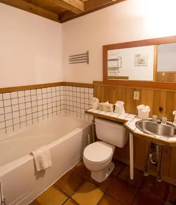 a bathroom with a tub and a toilet and a sink at Reef Point Cottages in Ucluelet