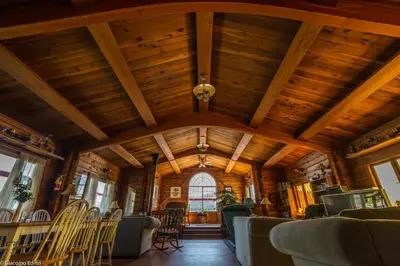 a room with a wooden ceiling and chairs at Alert Bay Lodge in Alert Bay