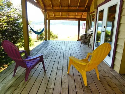 three chairs sitting on a porch of a house at Alert Bay Lodge in Alert Bay