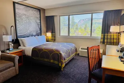 a hotel room with a bed and a window at Super 8 by Wyndham Castlegar BC in Castlegar