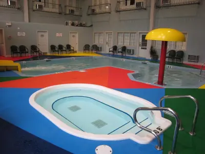 a swimming pool with a hot tub in a building at Super 8 by Wyndham Castlegar BC in Castlegar