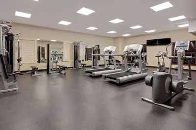 a gym with several treadmills and machines at Ramada by Wyndham Stettler in Stettler