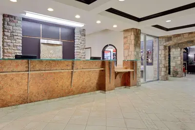 a lobby with a bar in a building at Ramada by Wyndham Stettler in Stettler