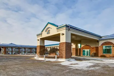 a large building with a parking lot in front at Canalta Stettler in Stettler