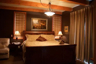 a bedroom with a bed with a dog sitting on it at Windborne Bed & Breakfast in Castlegar