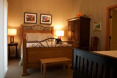 a bedroom with a bed and a table and two lamps at Windborne Bed & Breakfast in Castlegar