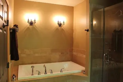 a bathroom with a tub and a glass shower at Windborne Bed & Breakfast in Castlegar