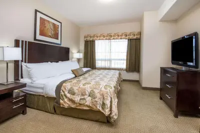 a hotel room with a bed and a flat screen tv at Ramada by Wyndham Wainwright in Wainwright