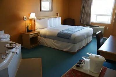 a hotel room with a bed and a bathroom at R&R Inn & Suites in Camrose
