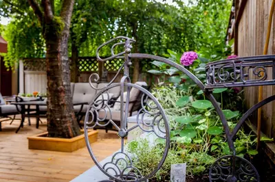 a metal bench sitting in a garden with flowers at O Canada House Bed & Breakfast in Vancouver