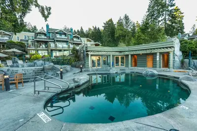 a house with a swimming pool in front of a house at Poets Cove Resort & Spa in Bedwell Harbour