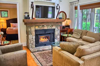 a living room with a fireplace with a tv on top at Poets Cove Resort & Spa in Bedwell Harbour